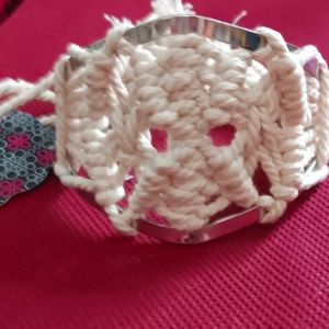 Macromae and metal bracelet off white in color.